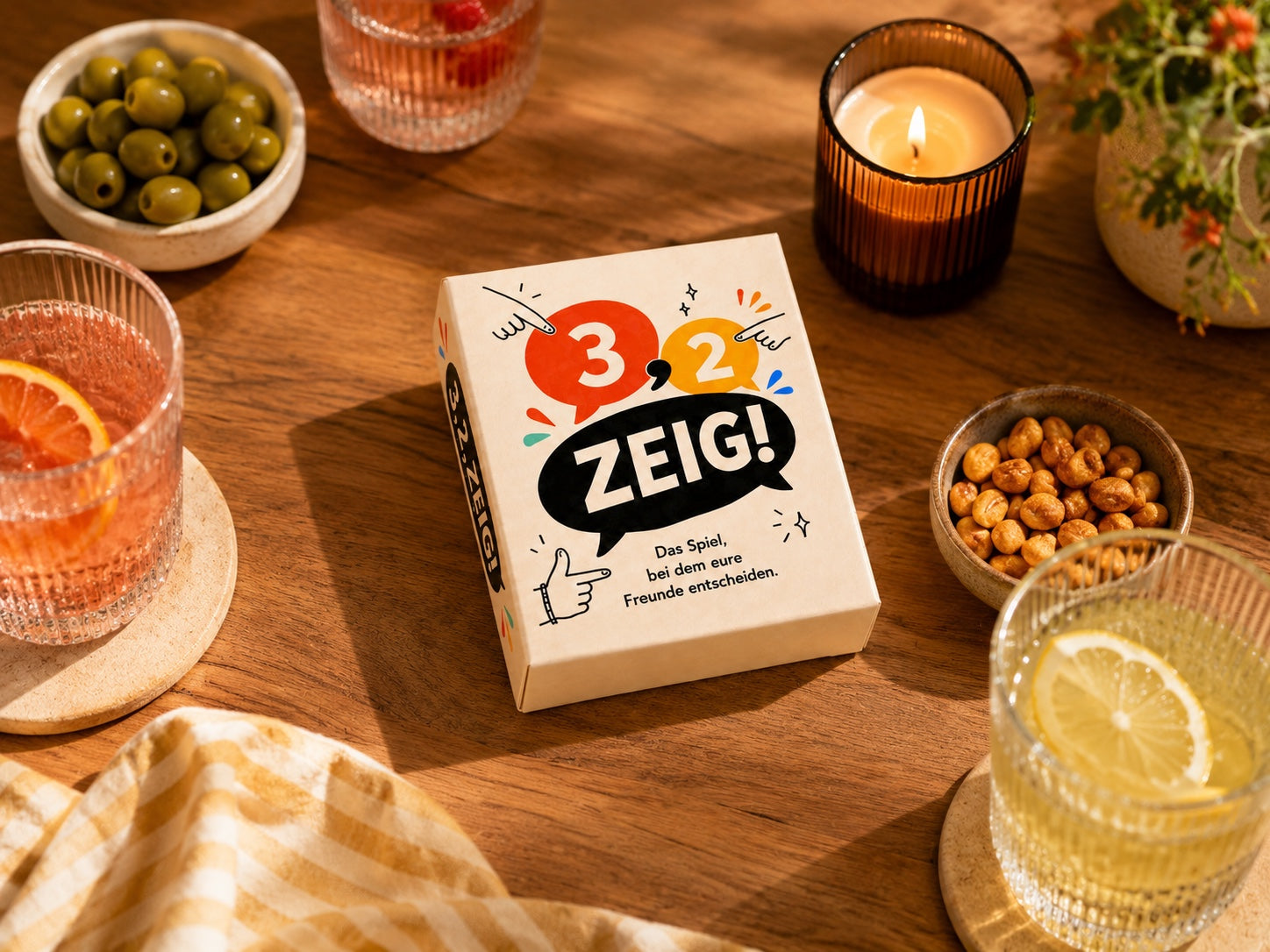 3,2,ZEIG! Spielbox auf einem gedeckten Tisch in geselliger Atmosphäre